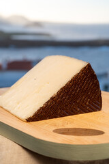 Spanish hard cheese, curado, manchego, goat cheese served outdoor with blue sea on background, close up