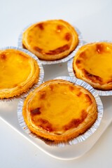 Portugal's traditional sweet dessert Pastel de nata egg custard tart pastry in cup close up