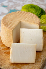 Cheese collection, piece of round fresh smoked Spanish goat cheese close up