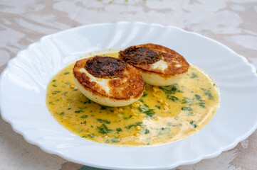 Les Oeufs Jeannette (Eggs Jeannette) with special filling and yellow sauce, vegetarian food