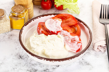 Salad with sliced tomato and stracciatella