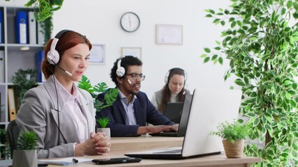 technical support for customers, friendly team of men and women with help of a headset and video communication on a laptop talk to customers in office