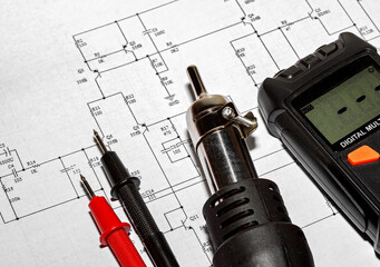 Red and black probes with a soldering hair dryer and multimeter
