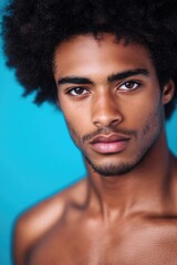 A striking close-up portrait of a young man with captivating eyes and hairstyle, exuding confidence and charm that is enhanced by the vivid background colors.