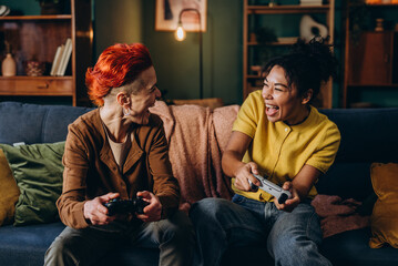 Women avid players express positive emotions playing together at home
