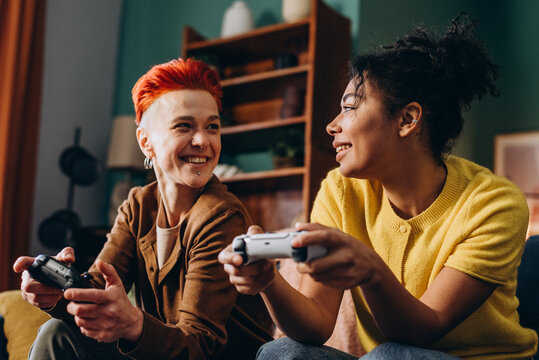 Smiling lesbians with joysticks enjoy video games sitting on sofa at home
- Powered by Adobe