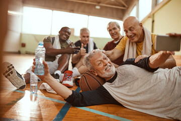 Senior men taking group selfie after basketball game