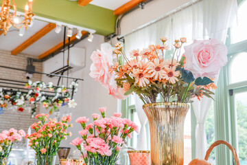 Beautiful flowers in vase on wooden table at bakery,living room interior,a lot of plants  in cozy home decor.
