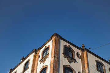 Perspectiva de un edificio moderno creando formas triangulares, en un día sin nubes. 