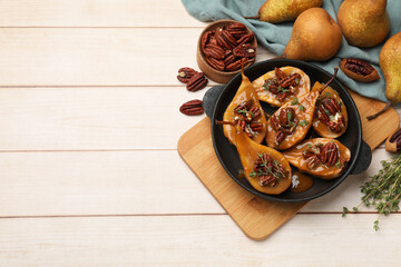 Delicious pears with caramel sauce, pecan nuts and thyme on wooden table, top view. Space for text