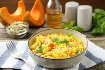 Delicious pumpkin risotto served on wooden table, closeup