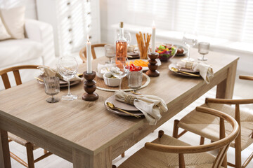 Stylish table setting with dishware, cutlery and burning candles indoors