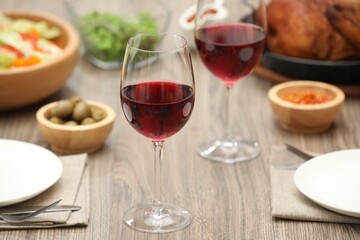 Red wine and delicious dinner served on wooden table