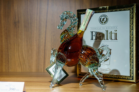 Exquisite moldovan brandy in decorative glass horse bottle on wooden shelf. March 1, 2023 Balti Moldova
