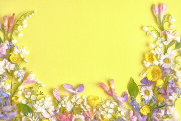 floral layout from different wildflowers on a yellow background. Top view, flat lay
