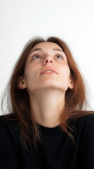 Young woman looking up with hope and wonder in studio portrait