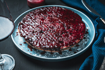 Cherry chocolate clafutis on a light blue plate on a dark background. French pie according to a traditional recipe. A quick homemade dessert.