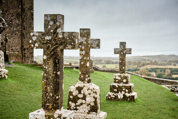 A group of weathered stone crosses stands in the historic cemetery at the Rock of Cashel, County...