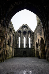 A breathtaking view of the ruins of the medieval cathedral at Rock of Cashel in County Tipperary, Ireland. The grand gothic arches and stone walls tell the story of this historic landmark's rich past.