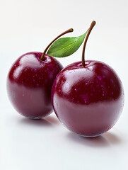 Fresh red plums with vibrant color and shiny texture against a light background