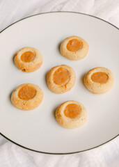 Delicious home-baked cookies served on a white plate with a golden filling during a cozy afternoon gathering