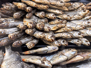 Dried fish arranged in a colorful display at a bustling market stall