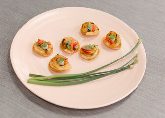 Deliciously arranged grilled shrimp appetizers with fresh vegetables on a light plate at a stylish dining setting
