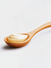 Spoon filled with creamy sauce on white background showcasing culinary artistry and kitchen essentials