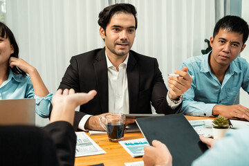 Diverse group of business analyst team analyzing financial data report paper on office table. Chart and graph dashboard by business intelligence analysis for strategic marketing planning Habiliment