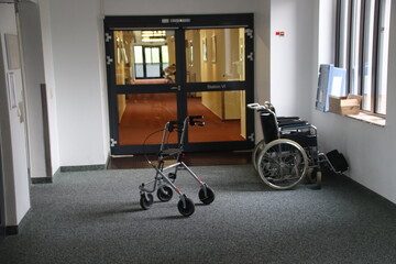 Rollstuhl, Rollator oder Gehhilfe auf einem Flur in einem Altenheim stehend 
