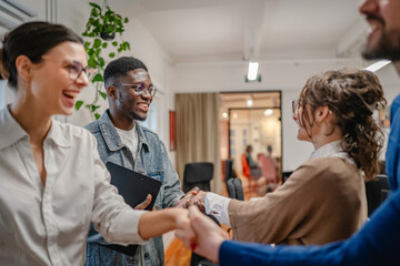 man and woman colleagues shake hands on business meeting in the office