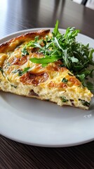Delicious homemade quiche with fresh arugula on white plate