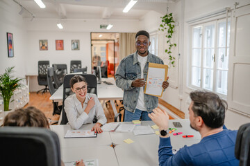 young afro american businessman representing statistics to his work team