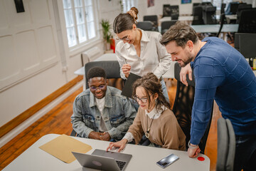 Obraz premium multicultural colleagues work together on laptop in the office