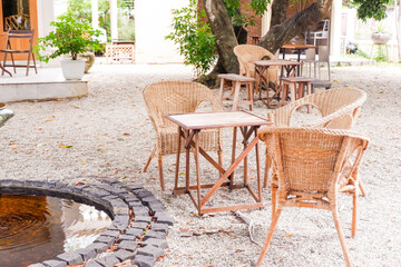 Wicker table and chairs at cozy house or restaurant in garden,modern home decor,Contemporary interior design of dining space,rattan furniture,minimal concept.