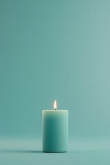 Softly glowing candle illuminates serene turquoise background, e