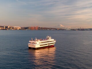 Ferry cruises Puget Sound, passengers enjoy the views of the Seattle skyline and Mount Rainier. ,...