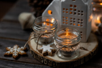 Creating holiday mood, festive atmosphere at home. Christmas spirit, atmospheric composition with handmade aroma candles made from simple glass jars, homemade gingerbread cookies, anise cinnamon scent