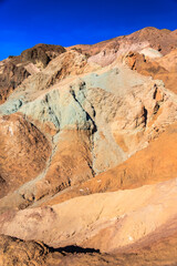 A mountain range with a blue and green rock formation