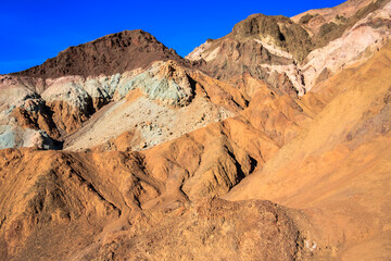 A mountain range with a rocky, brown and green hillside
