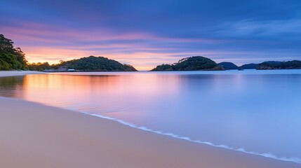 Fototapeta premium Serene beach at sunrise with soft golden light reflecting on calm waters. Highlights natural beauty and tranquility.