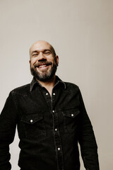 Obraz premium Vertical headshot of smiling bearded mature man looking away posing indoor. Mindset concept.