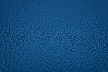 water drops on the blue metal surface, abstract background, and macro window after the rain, blue car after carwash 