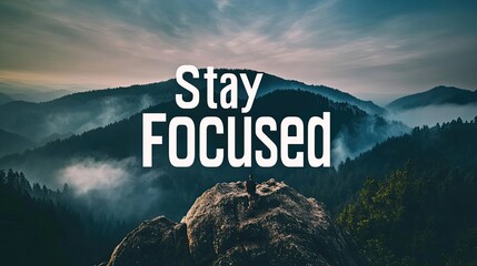 Person meditating atop mountain peak, misty valley background, 'Stay Focused' text overlay, motivational poster