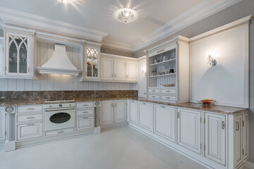 A white kitchen set with a brown marble countertop with an exclusive design in a .classic style.