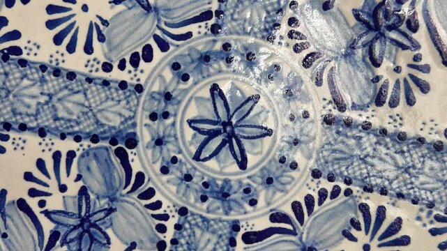A blue and white plate with flowers and dots