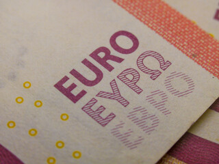 Fotografía macro de billetes y moneda de la unión europea.