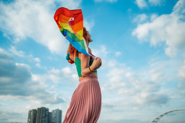 Woman waving rainbow flag celebrating freedom and equality during lgbt pride parade