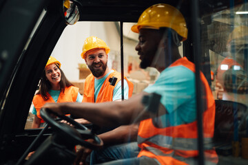 Warehouse workers having fun while driving forklift
