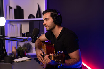 Host channel of smart influencer in creative audio on live streaming to fanclub with sing with play guitar music blogger using headset and mic social media online at neon light modern studio. Surmise.